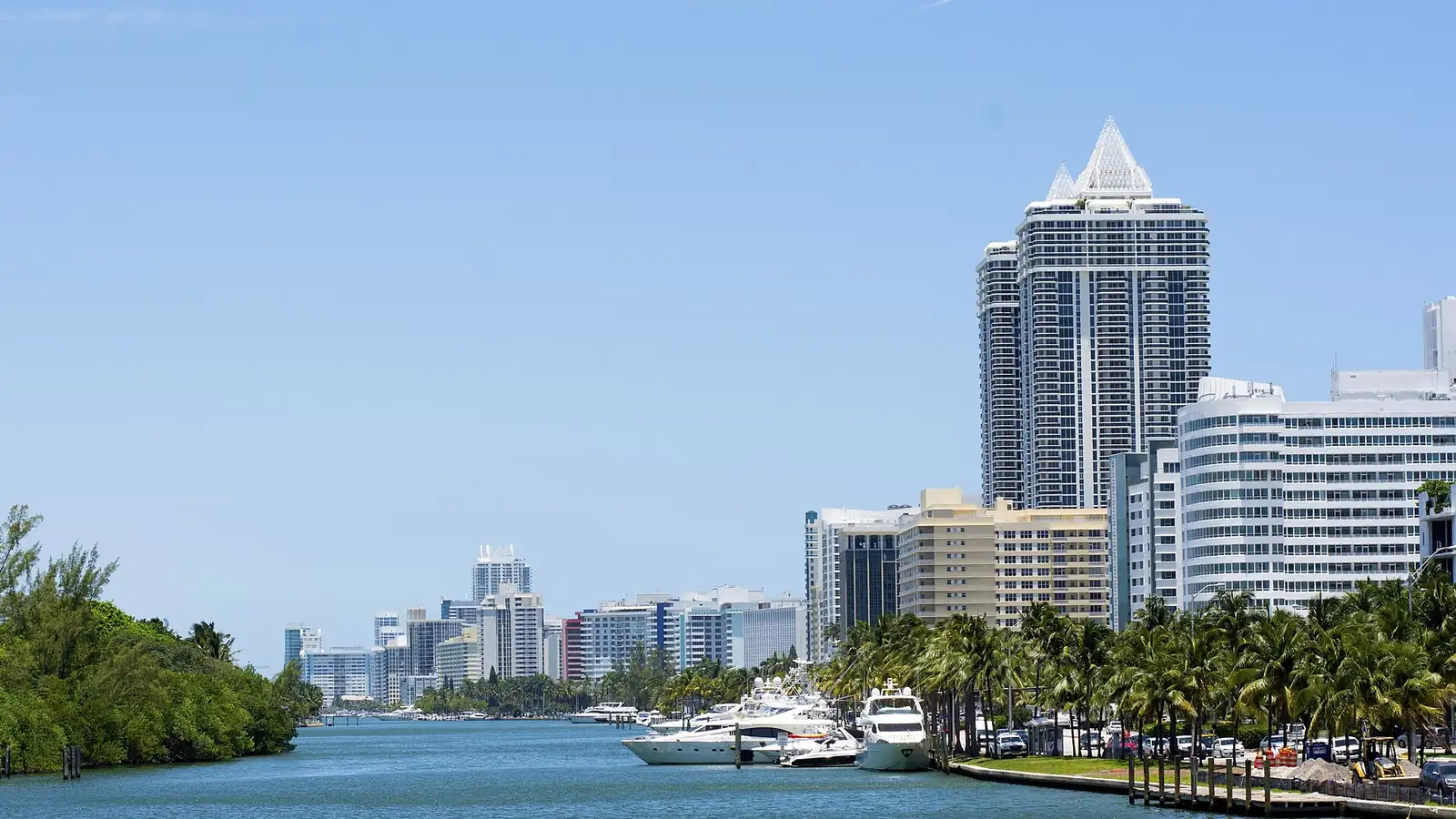 Boats moored along a Miami waterway with high-rise buildings behind